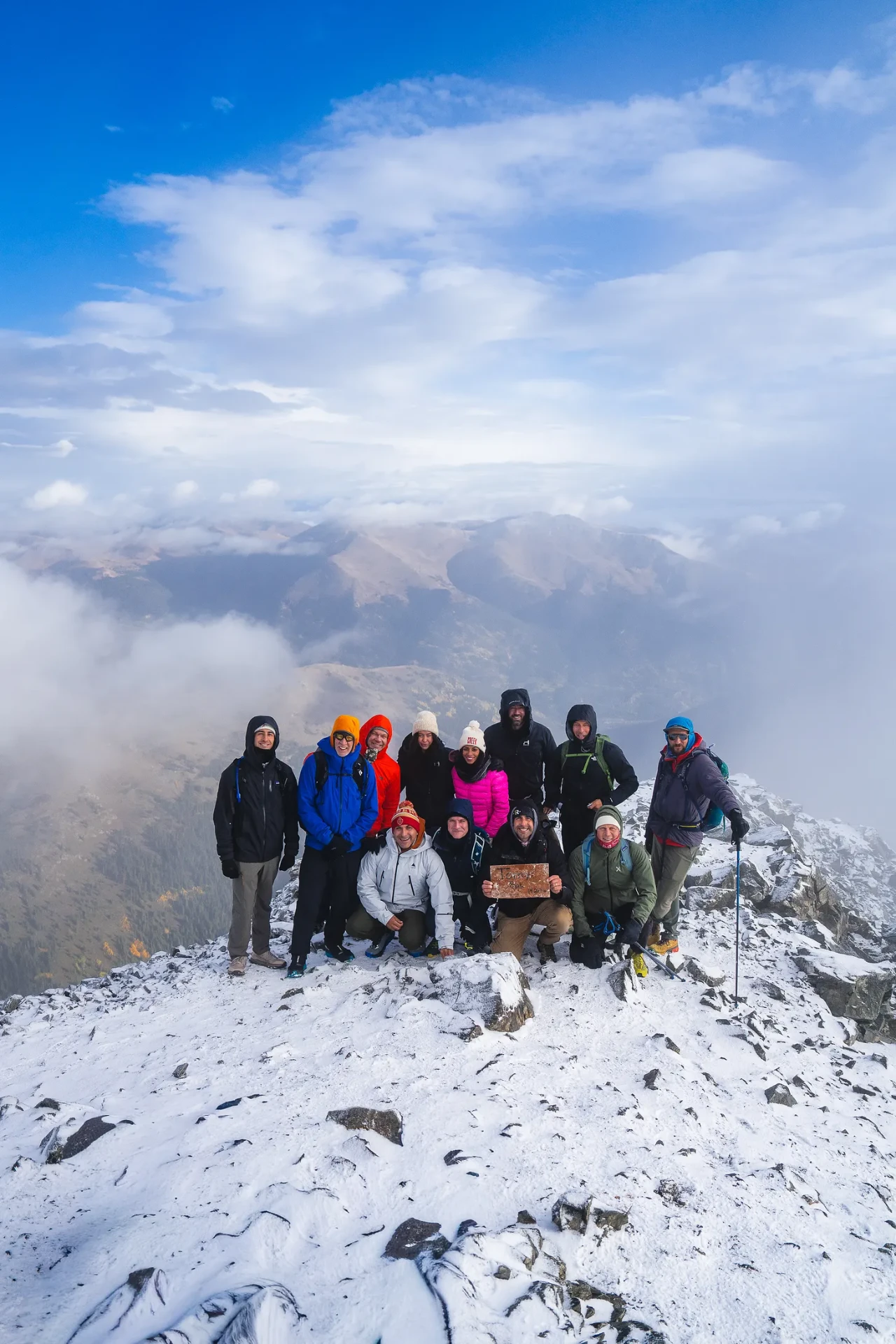 The expedition group gathered on a snow-covered summit in the clouds