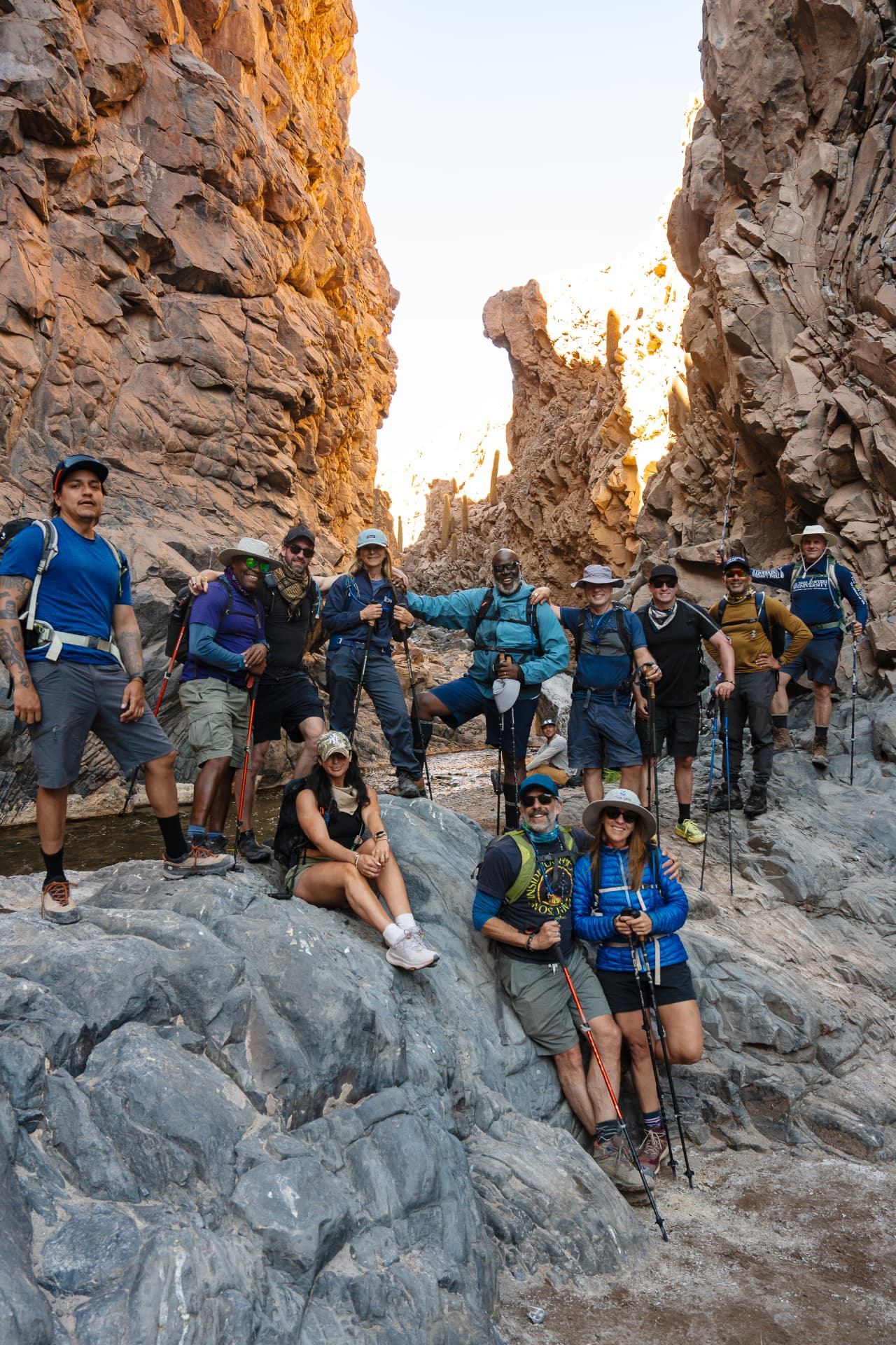 The group relaxed together on sunlit canyon rocks, arms around each other