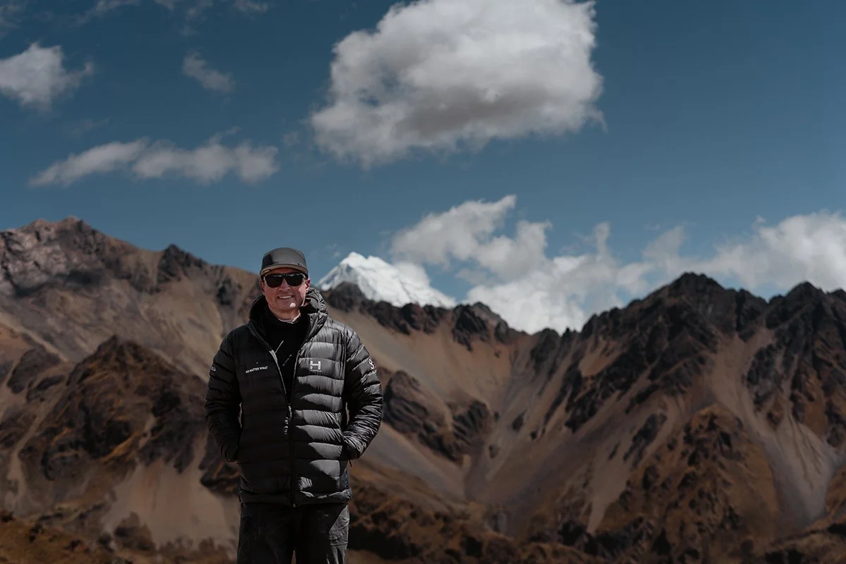 A leader standing in front of snow-capped Andes peaks
